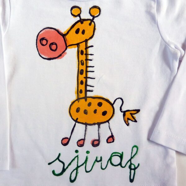 Detail van handbeschilderd giraf t-shirt met vrolijke kindertekening van een giraf, een perfect kraamkado